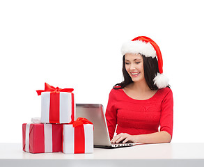 Image showing woman with gift boxes and laptop computer