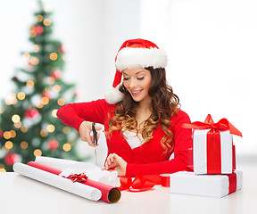 Image showing smiling woman in santa helper hat with gift box