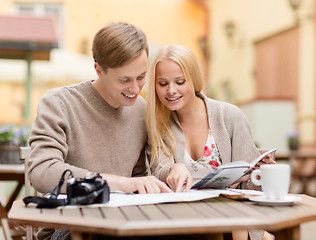 Image showing couple with map, camera and travellers guide