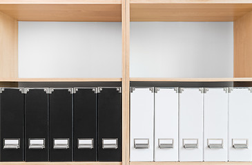 Image showing Bookcase with black and white folders