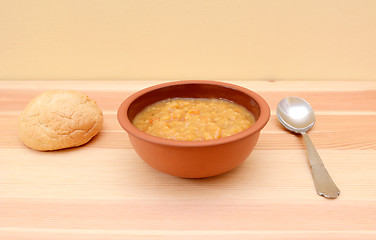 Image showing Hearty lentil soup served with a crusty bread roll