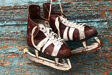 Image showing vintage pair of mens  ice skates on a wooden wall