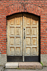 Image showing large yellow door in brick wall