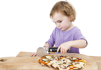 Image showing cute girl cutting fresh homemade pizza