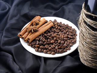 Image showing Champagne bottle, coffee beans, cinnamon and star anis on black material