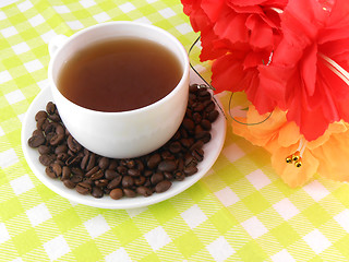 Image showing Cup of coffee with coffee beans with flowers