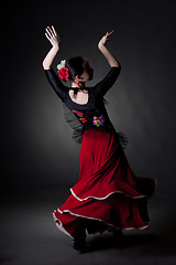 Image showing young woman dancing flamenco on black