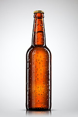 Image showing Beer bottle with water drops isolated on white