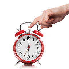 Image showing hand and red old style alarm clock isolated on white