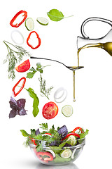 Image showing Falling vegetables for salad and oil isolated