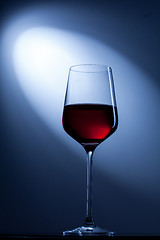 Image showing red wine in glass on blue