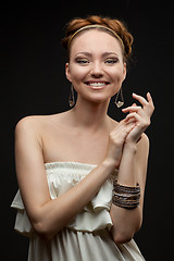 Image showing portrait of smiling beautiful young woman on black