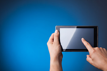 Image showing Hands holding Tablet PC on blue