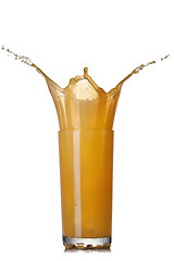 Image showing Splash of orange juice in glass isolated on white