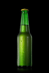 Image showing beer bottle with water drops isolated on black