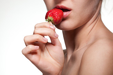 Image showing Young woman biting strawberry isolated on white