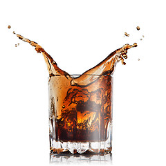 Image showing splash of cola in glass with ice cubes isolated on white