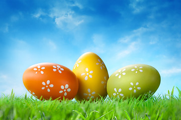 Image showing Color easter eggs in the grass against blue sky