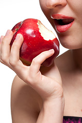 Image showing Young woman biting red apple isolated on white