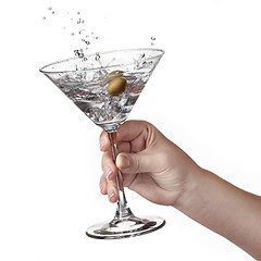 Image showing Splash of martini in womans hand isolated