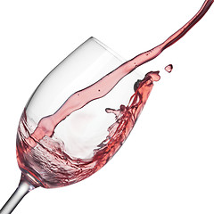 Image showing Splash of rose wine in wineglass on white