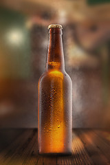 Image showing Cold beer bottle with drops, frost and vapour