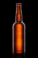 Image showing Beer bottle with water drops isolated on black