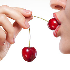 Image showing Young woman with cherry isolated on white