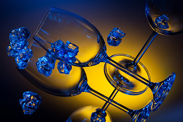 Image showing ice and empty wineglasses on color background