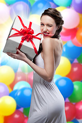 Image showing Young smiling woman holding gift