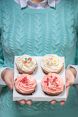 Image showing woman holding cupcakes in hands