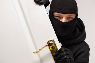 Image showing Burglar sneaking in a open house door