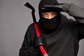 Image showing Burglar with a crowbar on the shoulder.