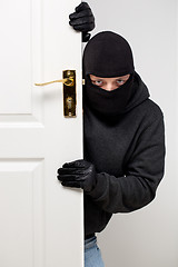 Image showing Burglar sneaking in a open house door