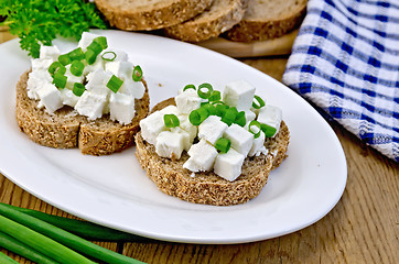 Image showing Bread with feta cheese and green onions on a board