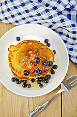 Image showing Flapjacks with blueberries and a fork on a board