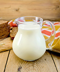 Image showing Milk in a jug with rye bread and red napkin