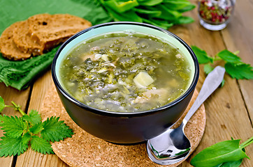 Image showing Soup green of sorrel and nettles with bread on the board