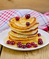 Image showing Flapjacks with cranberries and honey on the board