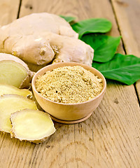 Image showing Ginger powder in a bowl with the root and leaves