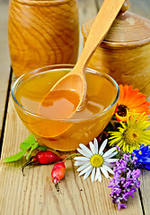 Image showing Honey with flowers and briar on the board