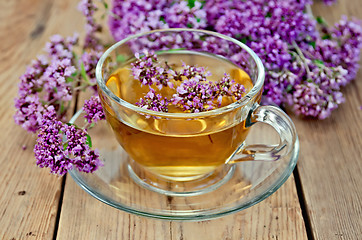 Image showing Herbal tea from oregano in a glass cup on a board