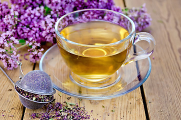 Image showing Herbal tea of oregano with strainer in a glass cup