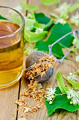 Image showing Herbal tea from linden flowers in a mug with a strainer on the b