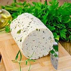 Image showing Cheese homemade with herbs and knife on board