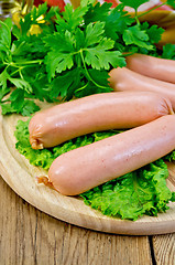 Image showing Sausages on a board with parsley and oil