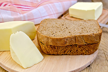 Image showing Rye bread with cheese and butter on board