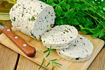 Image showing Cheese homemade with herbs cut on a board