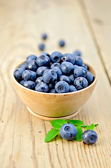 Image showing Blueberries in a wooden bowl on the board