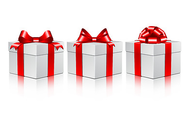 Image showing Three white gift boxes with a red bows.